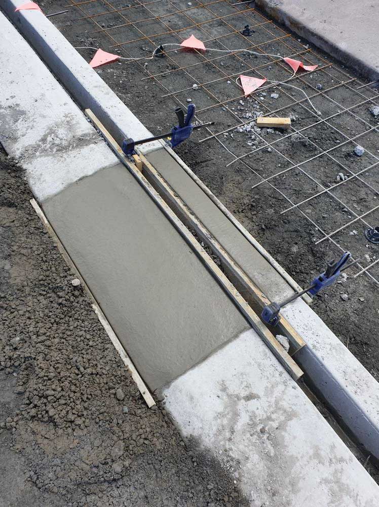 Concrete kerb section formed beside reinforcing mesh